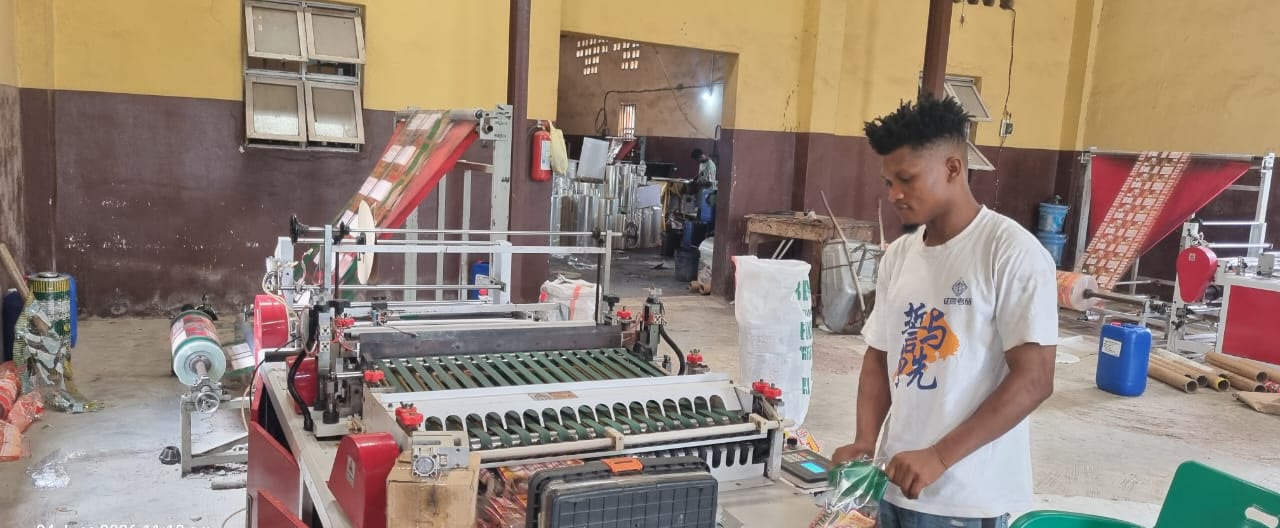 Our team operating a packaging machine in Asaba